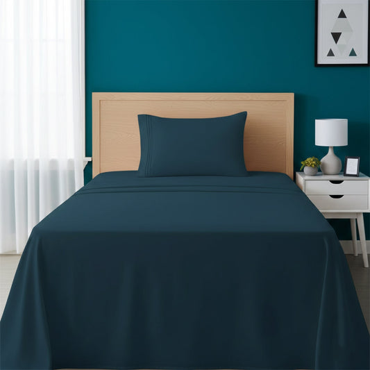 Red bedspread on a wooden bed with a white nightstand and decor items in the background.