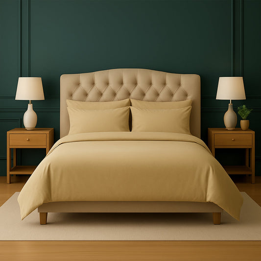 Neatly made bed with beige bedding in a bedroom setting.