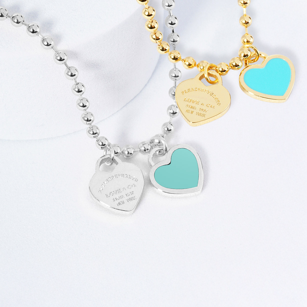 Three necklaces with heart-shaped charms on a white background