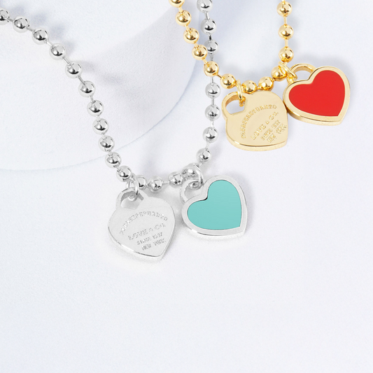 Two necklaces on mannequin busts with a blurred background