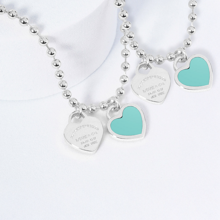 Silver necklaces with turquoise heart charms on a white background