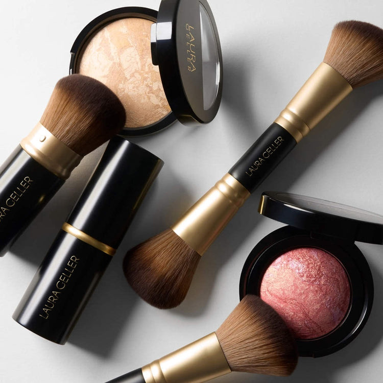 Makeup brushes and compacts on a light gray background with 'Laura Geller' branding.