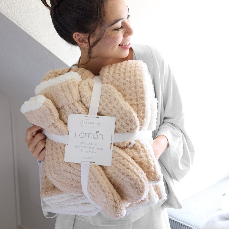 Woman holding a beige blanket with a Lemon label