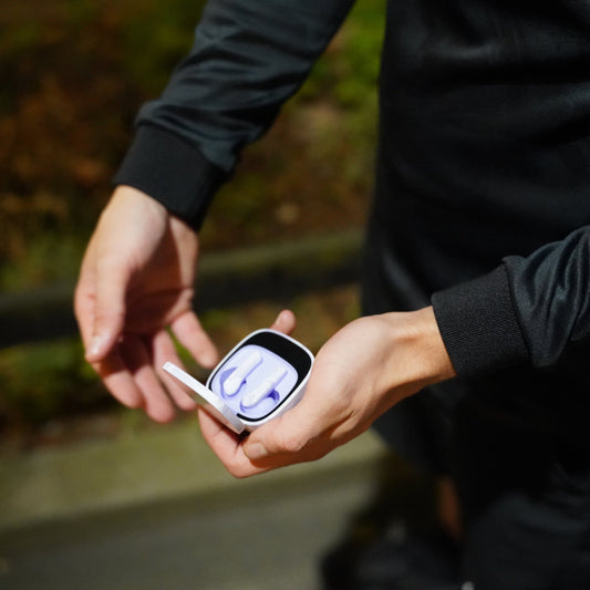 Pink wireless earbuds with charging cases on a white background