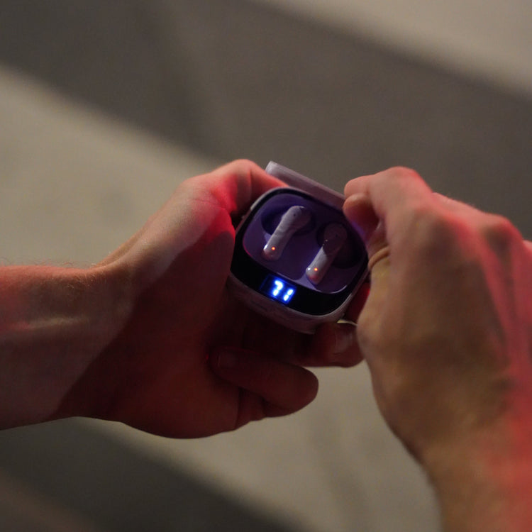 Close-up of a hand holding a small electronic device with glowing red and blue lights.
