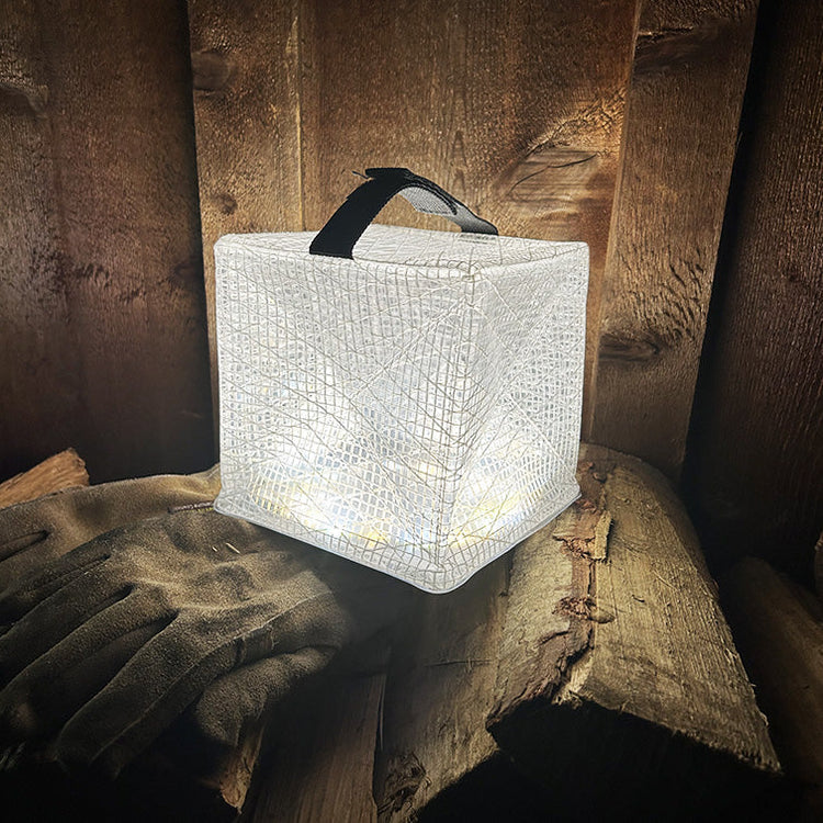MegaPuff lantern illuminating a wood pile for bright outdoor lighting.