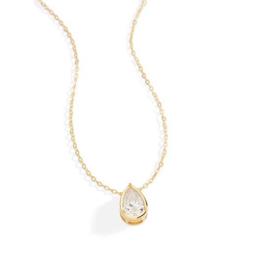 Gold necklace with a teardrop-shaped diamond pendant on a white background