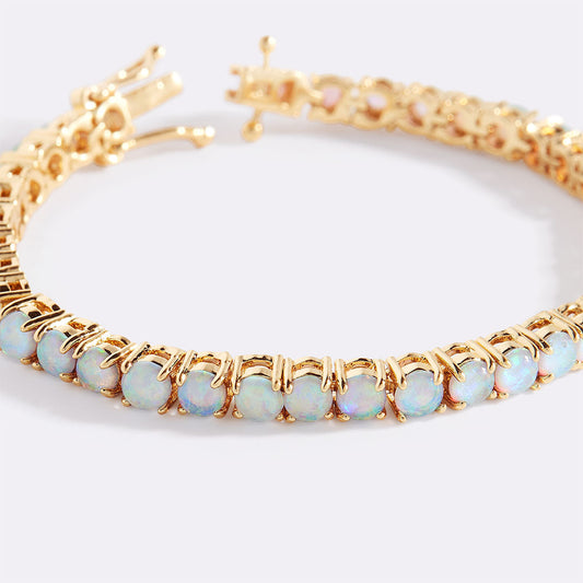 Gold bracelet with opal stones on a white background