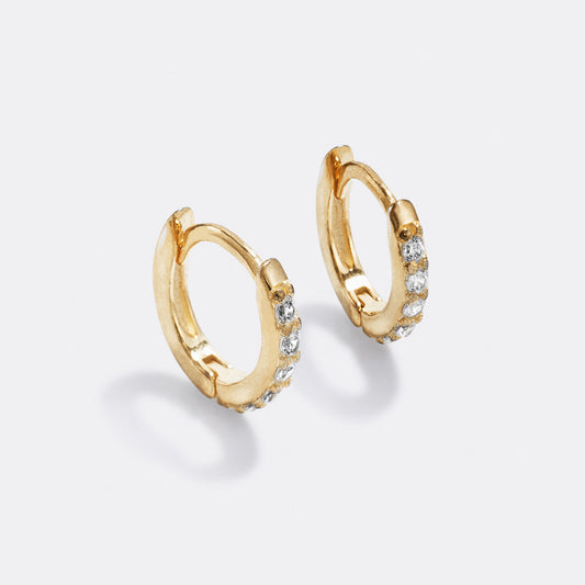 Gold hoop earrings with small diamonds on a white background
