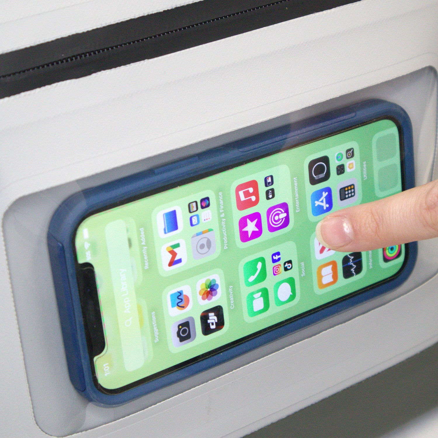 Phone with app icons on a screen held by a finger against a white background