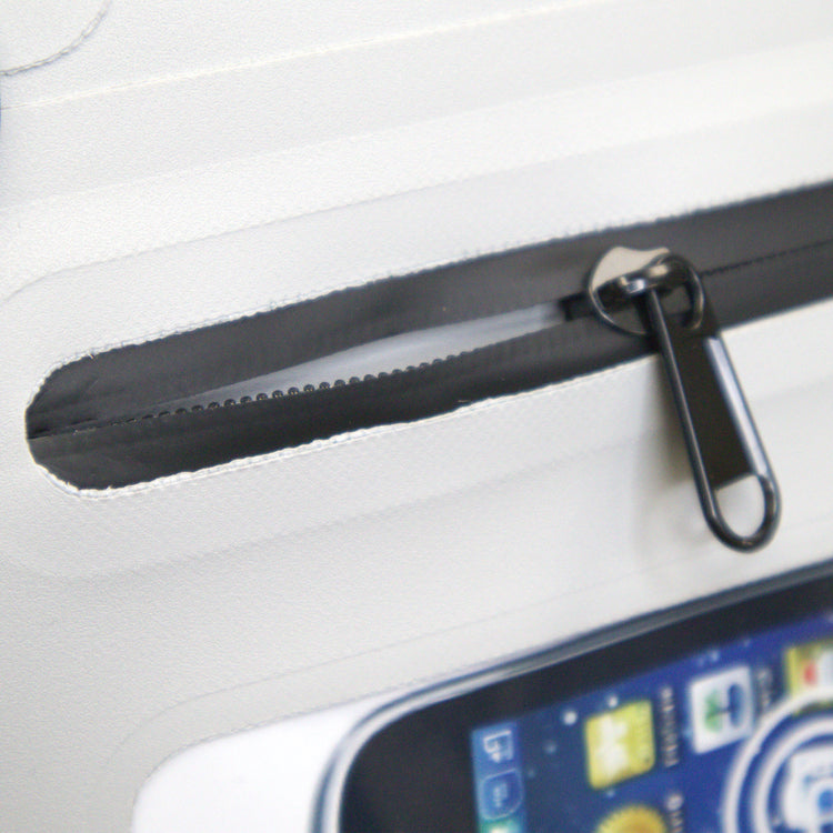 Close-up of a black zipper on a white surface with a smartphone partially visible.