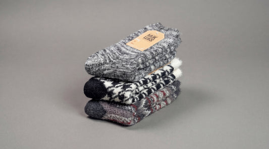 Stack of gray and black patterned socks on a gray background