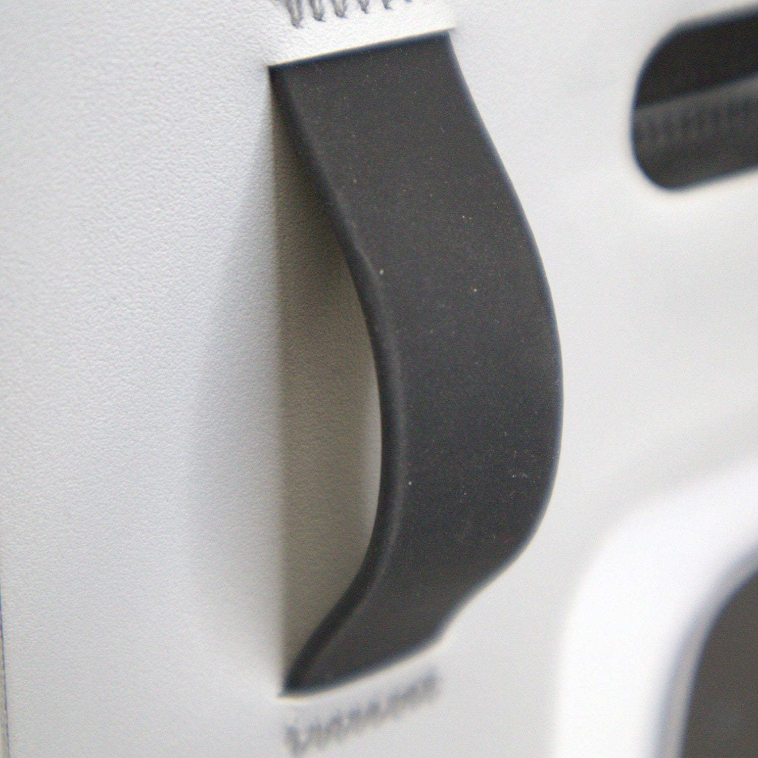Close-up of a black plastic component on a white background