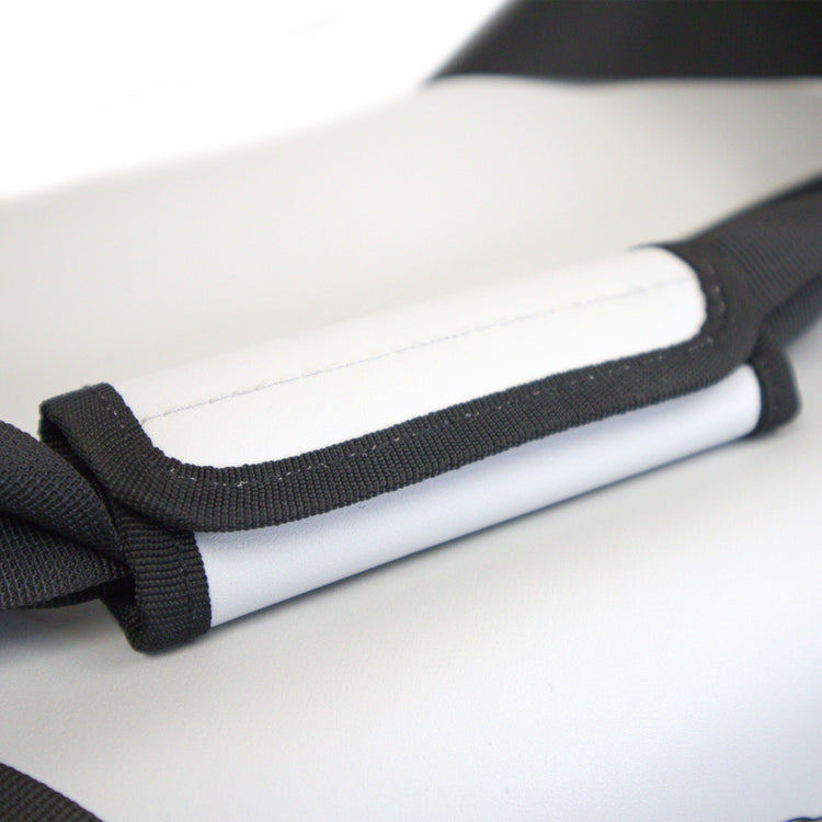 Close-up of a white and black protective gear with a strap on a light gray background