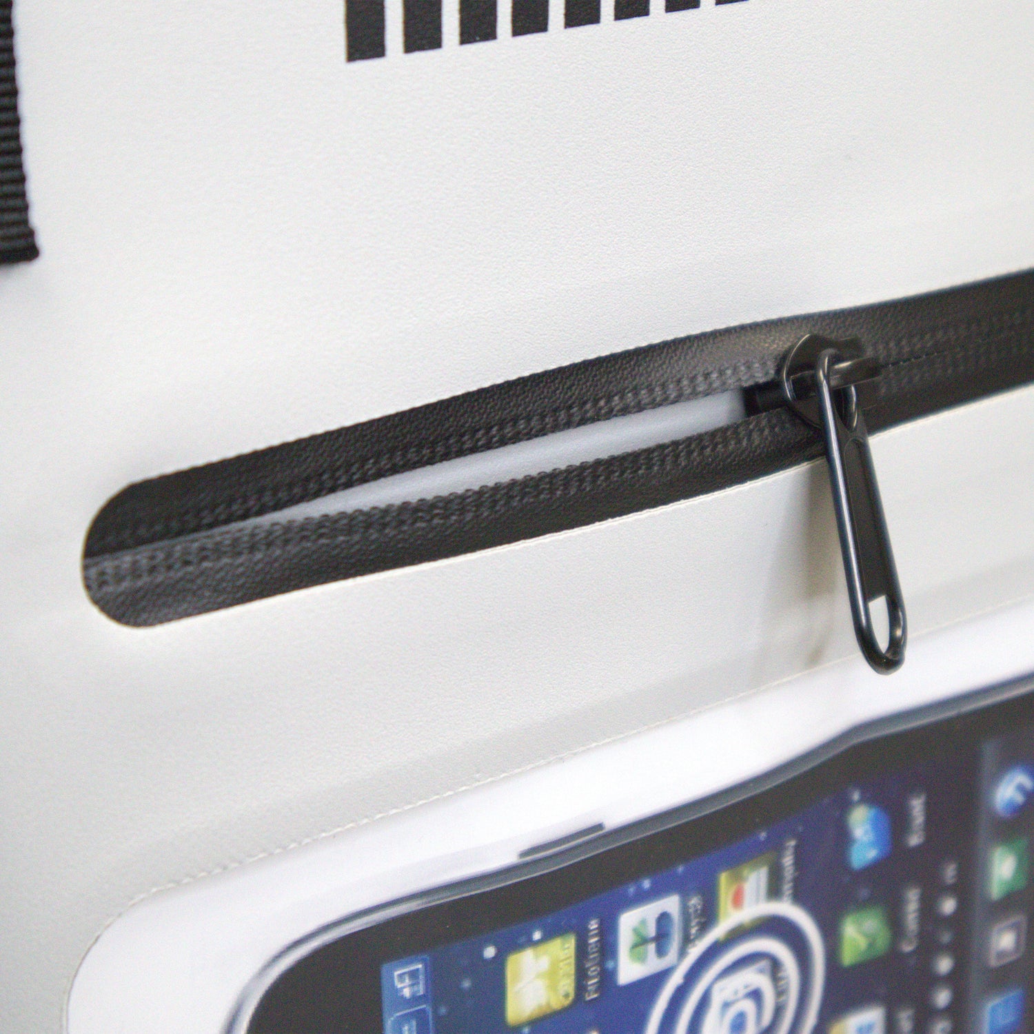 Close-up of a black zipper on a white surface with a smartphone displaying a screen.