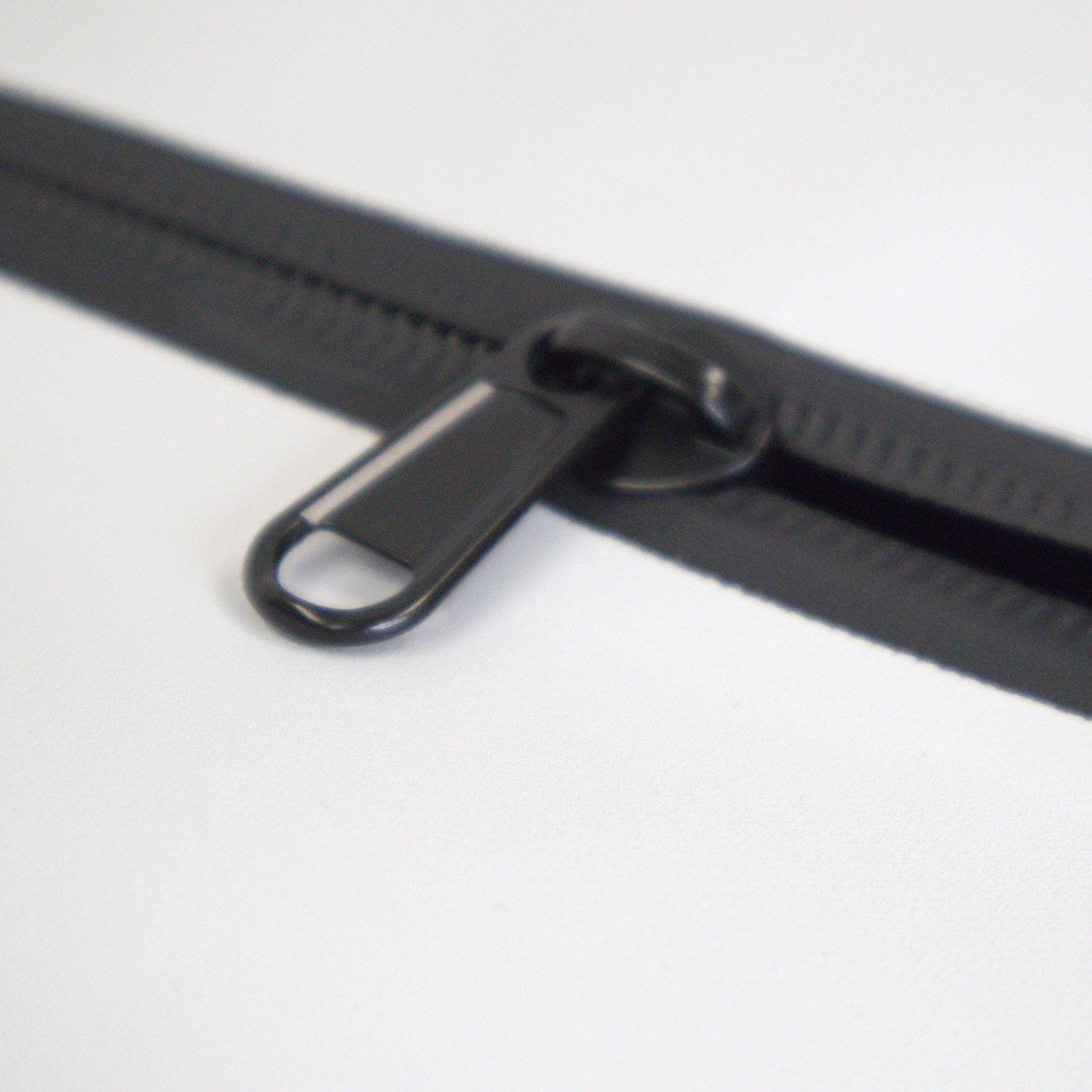 Close-up of a black zipper on a white background