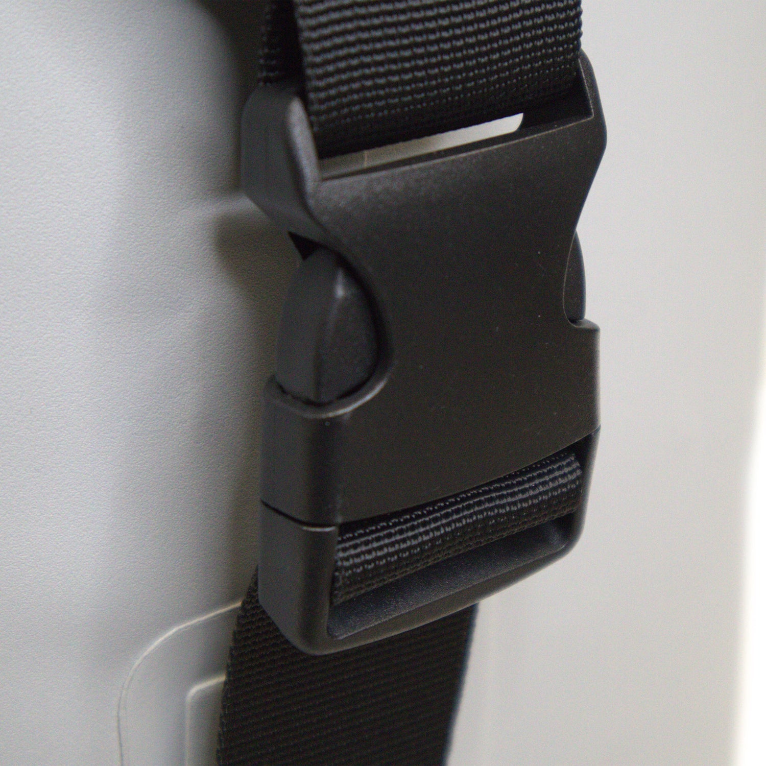 Close-up of a black strap with buckle on a gray background