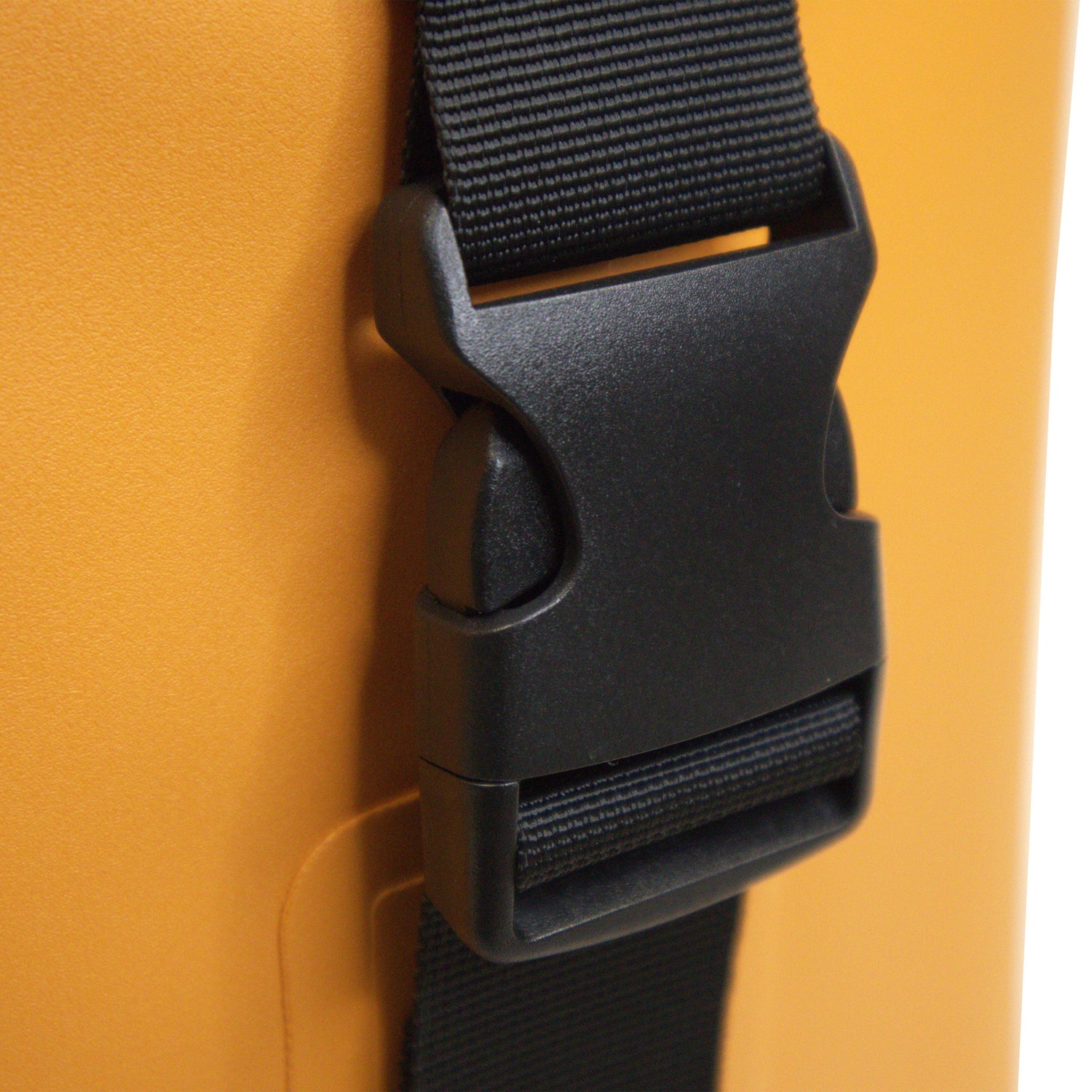 Close-up of a black strap buckle on an orange background