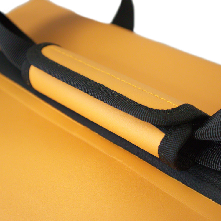 Close-up of a yellow bag with black straps on a white background