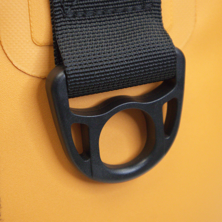 Close-up of a black strap with a buckle on a yellow background