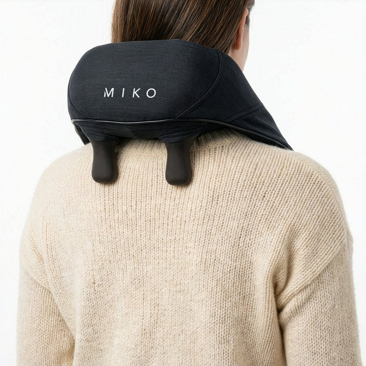 Person wearing a black Miko neck pillow on a white background