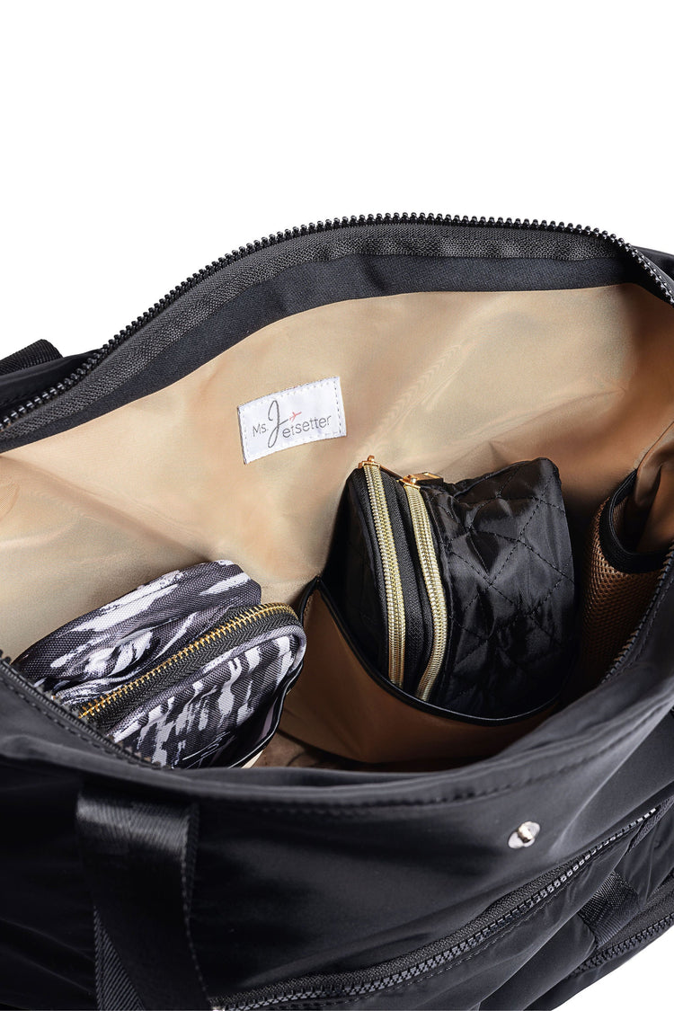 Black duffel bag with gold zipper accents on a white background