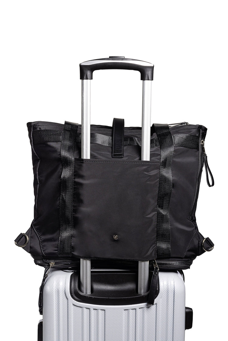 Black backpack on top of a white suitcase with a white background