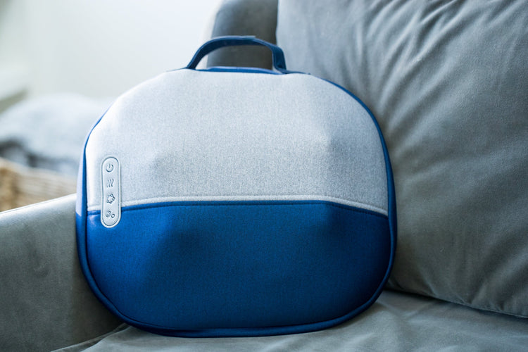 Blue and gray massage device on a couch