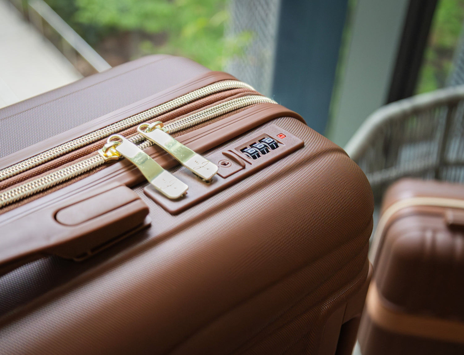 Brown suitcase with a visible tag on a blurred background