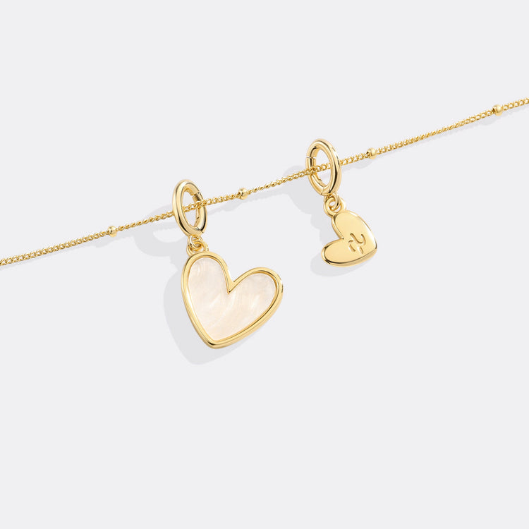 Gold heart-shaped pendants on a white background