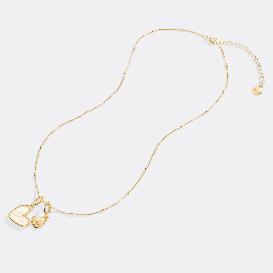 Gold necklace with heart-shaped pendants on a light gray background