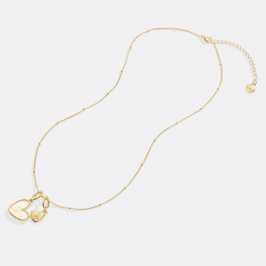 Gold necklace with a heart-shaped pendant on a white background