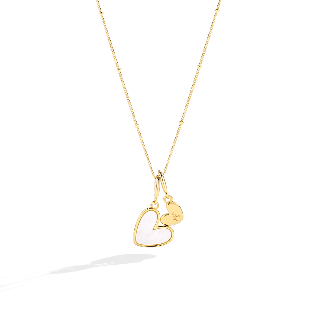 Gold necklace with a heart-shaped pendant on a white background