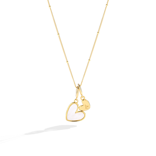 Gold necklace with a heart-shaped pendant on a white background