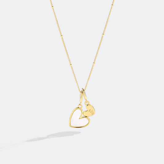 Gold necklace with a heart-shaped pendant on a white background