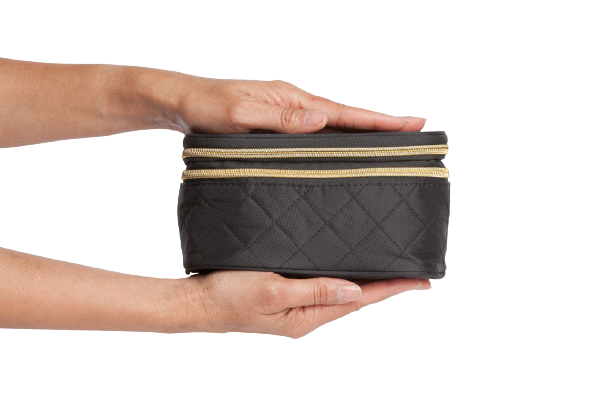 Person holding a black quilted bag with gold zipper on a white background