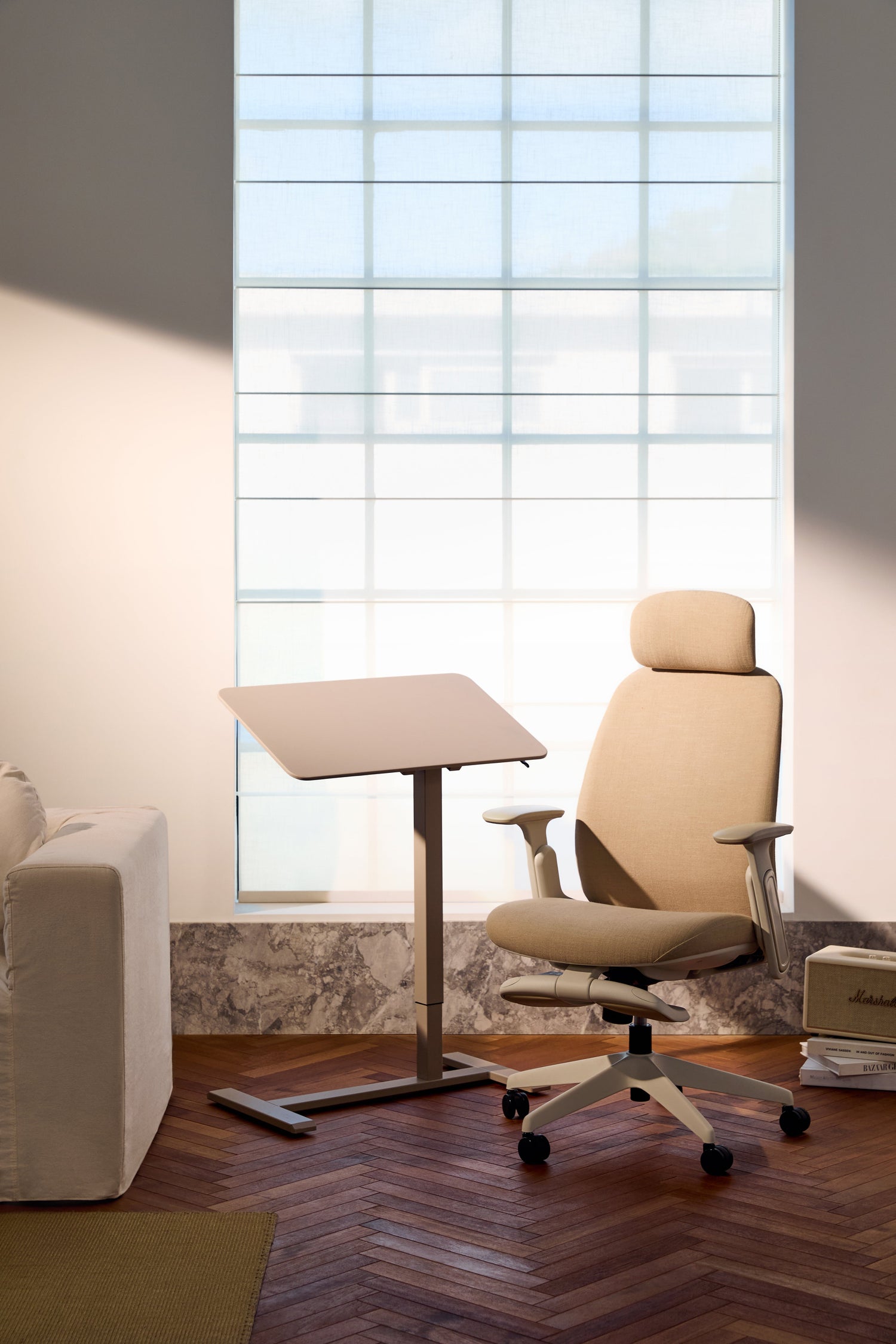 Beige office chair in a modern office setting with a large window.