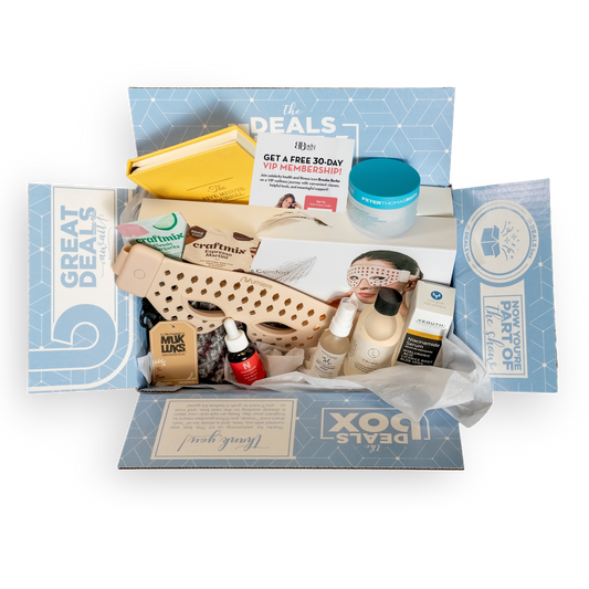 Open subscription box with various items including shoes, skincare products, and a face mask on a white background.