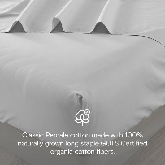 Gray bedding set on a bed in a bedroom with side tables and decor.