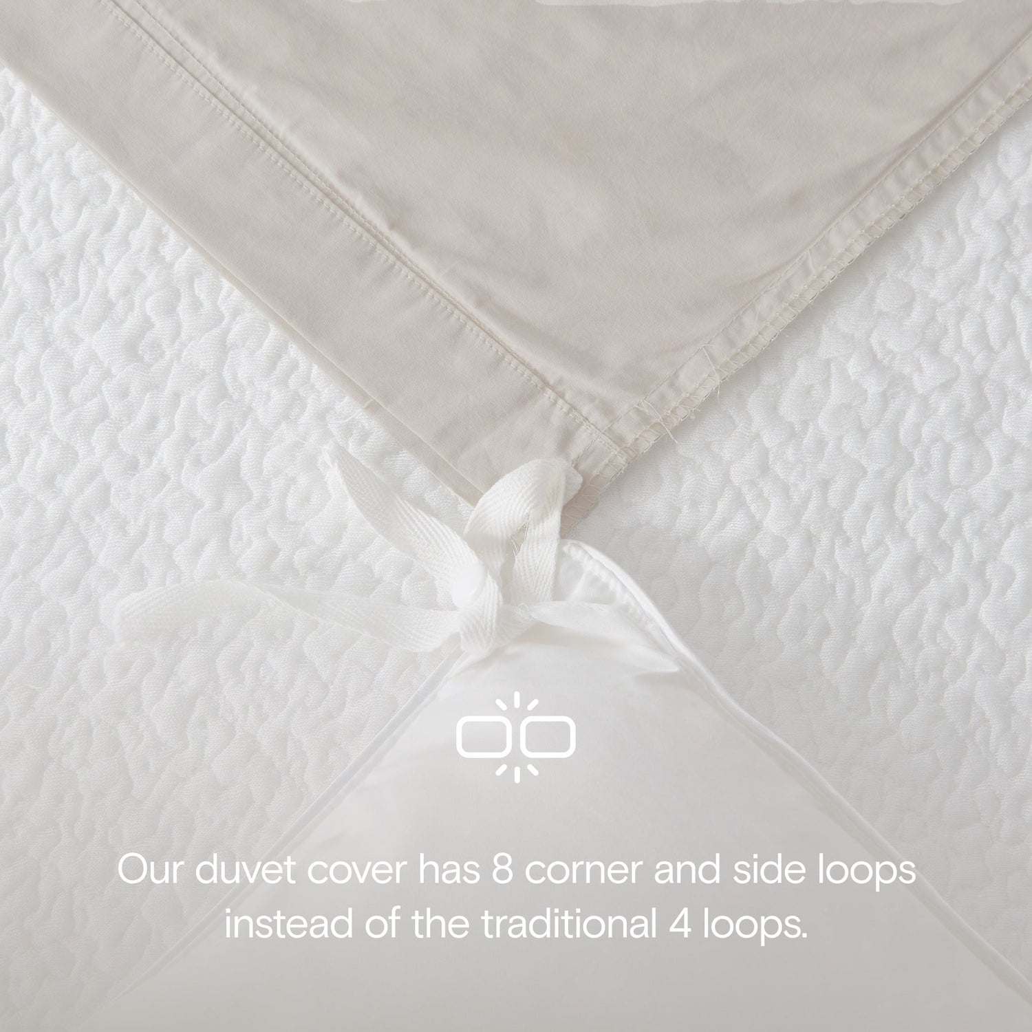 Close-up of a beige duvet cover with corner and side loops on a white background