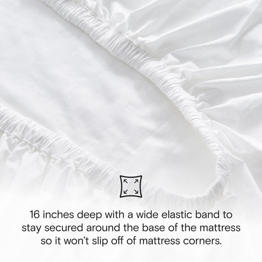 White bedding set on a bed in a bright bedroom with decor elements.