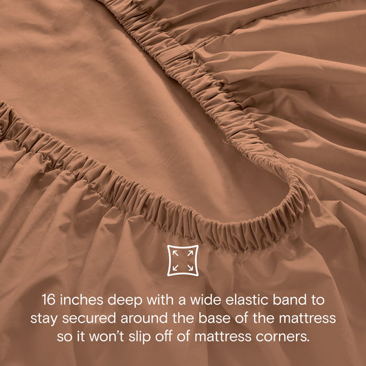 Brown bedspread set on a bed in a well-lit room with decor elements.