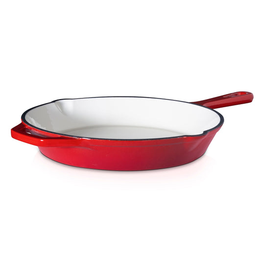 Red enameled cast iron skillet on a white background