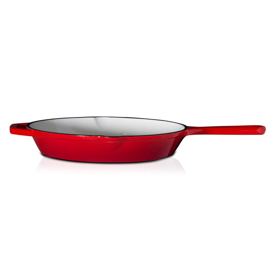 Red enameled cast iron skillet on a white background