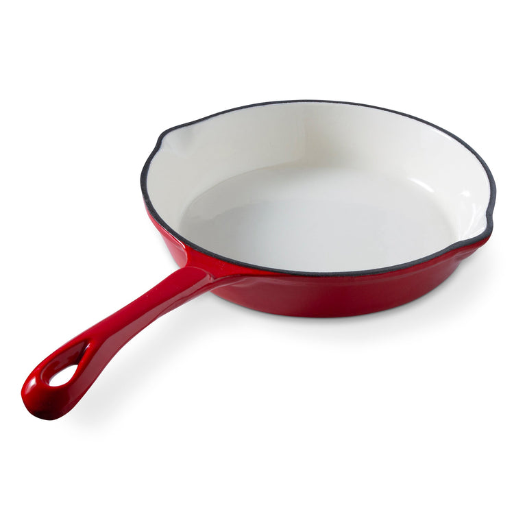 Red enameled cast iron skillet on a white background