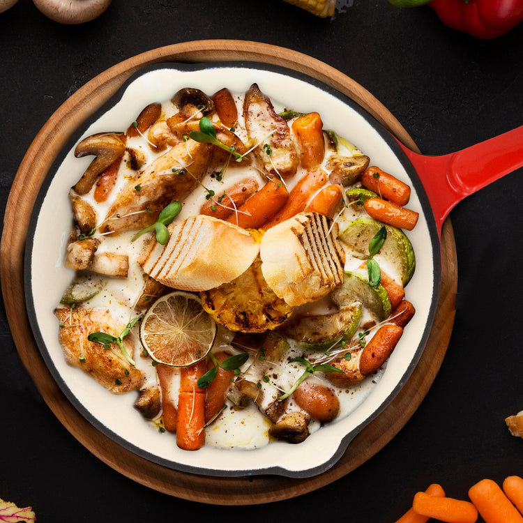 Assorted roasted vegetables on a white plate with a red handle, set against a dark background.
