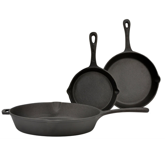Set of three black cast iron skillets on a white background