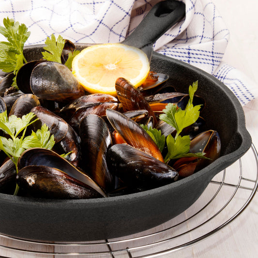Set of three black cast iron skillets on a white background