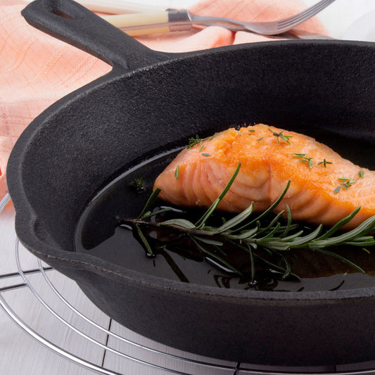 Set of three black cast iron skillets on a white background