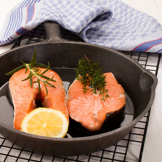 Set of three black cast iron skillets on a white background